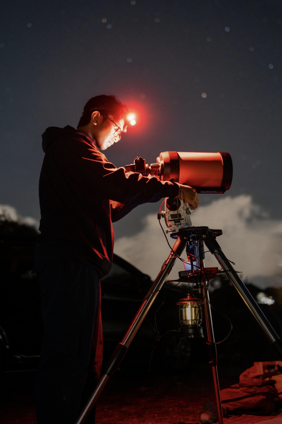 Astrophotographer aligning a telescope under the stars at Mount Batur